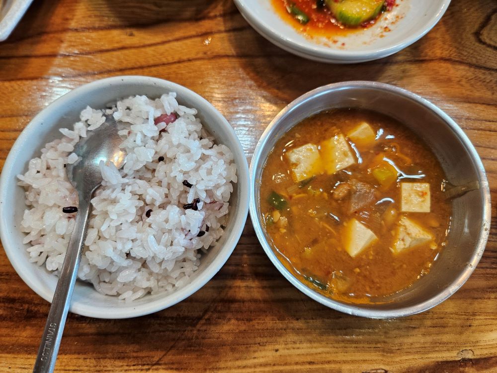 그릇에 덜어낸 따끈한 밥과 두부와 채소가 듬뿍 들어간 구수한 된장찌개