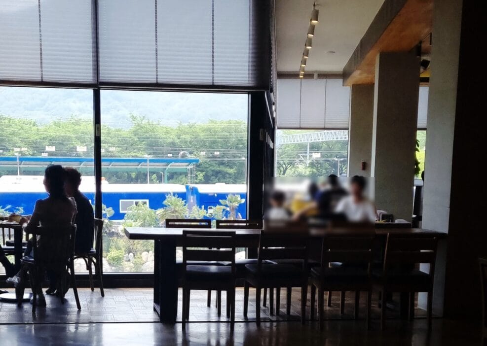 카페 통창 너머로 보이는 낭만적인 기찻길 풍경