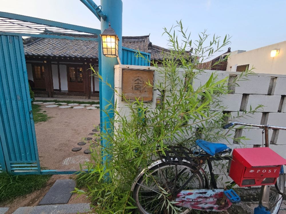 소옥 입구의 푸른 대문과 자전거가 놓인 아기자기한 담벼락