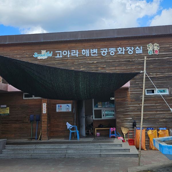 오류고아라해변 주차장 쪽에 위치한 깨끗하게 관리된 나무 왼관의 공중화장실 건물