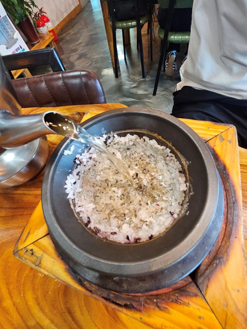 밥을 푼 뒤 누룽지가 남은 솥에 주전자로 따뜻한 물을 부어 숭늉을 만드는 모습
