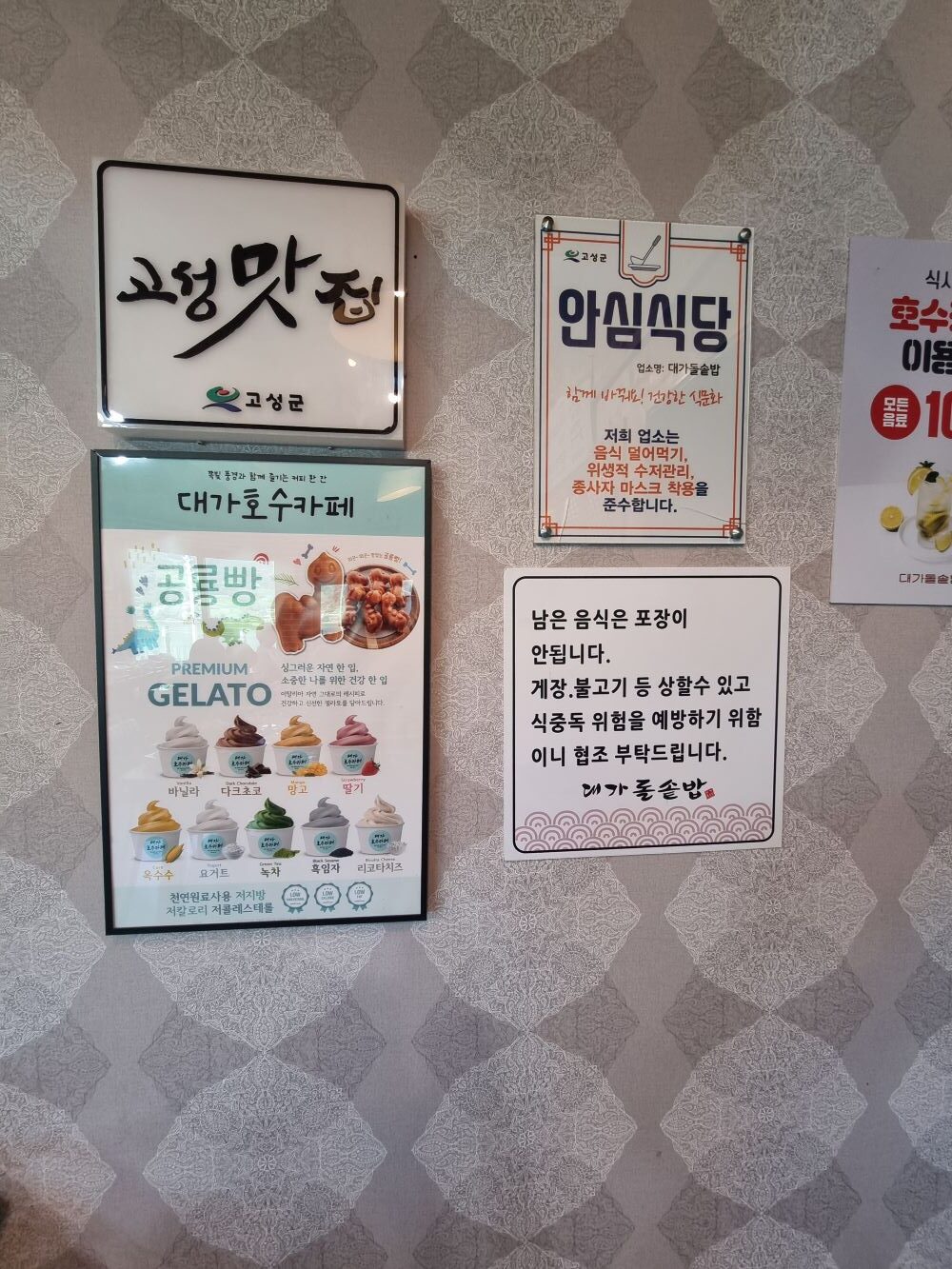 맛집 인증 현판과 안심식당 안내문, 메뉴판이 붙어 있는 벽면
